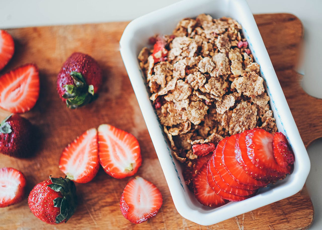 digital-01 Healthy breakfast option with fresh strawberries and cereals in a white dish.
